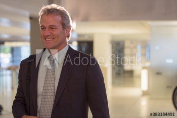 Smiling senior businessman in office lobby Smiling senior businessman in office lobby