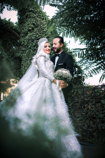 Smiling Woman Wearing White Wedding Abaya Beside Man Wearing Black Tuxedo during Day