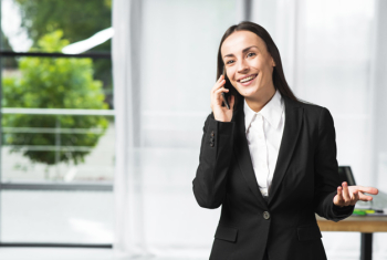 Smiling young businesswoman taking on cellphone gesturing Smiling young businesswoman taking on cellphone gesturing