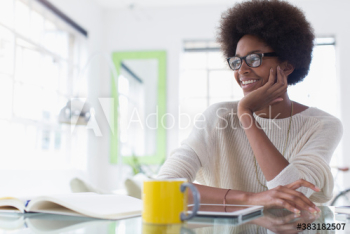 Smiling young woman with afro working from home Smiling young woman with afro working from home