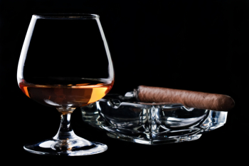 Snifter glass of cognac and cigar Snifter glass of cognac and cigar
