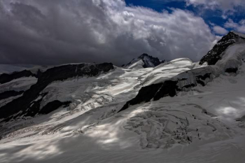 snow capped mountains under nimbus clouds snow capped mountains under nimbus clouds