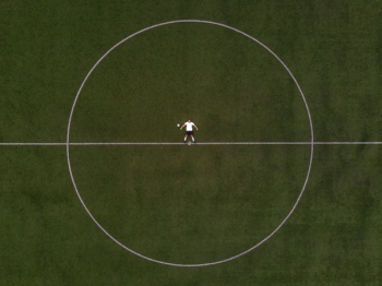 Soccer Player Laying In The Center Circle Soccer Player Laying In The Center Circle