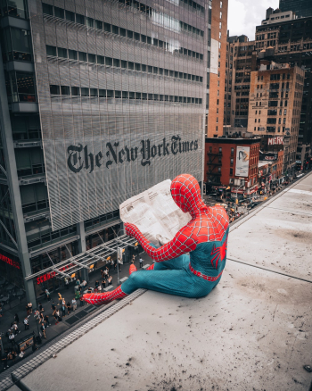 Spiderman Reading Newspaper on Top of Building Spiderman Reading Newspaper on Top of Building