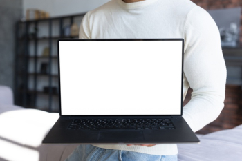 Standing man holding laptop mock-up Free Photo