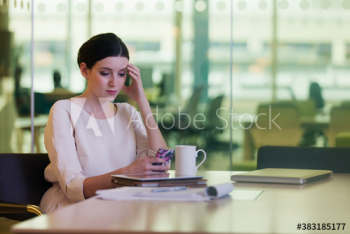 Stressed corporate businesswoman using smart phone in office Stressed corporate businesswoman using smart phone in office