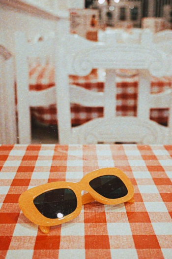 Sunglasses With Orange Frames on Checkered Tablecloth
