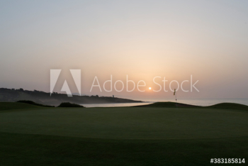 Sunset behind tranquil ocean golf course Sunset behind tranquil ocean golf course