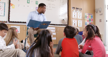 Teacher reading kids a story in an elementary school class Stock ...