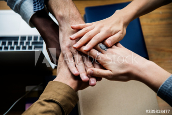 Team of business people stacking hands Team of business people stacking hands