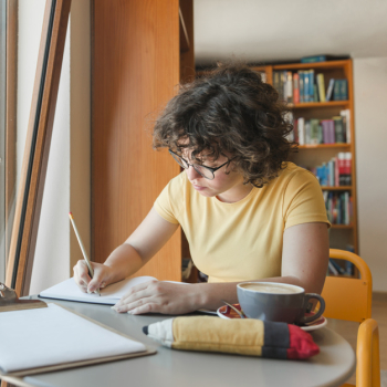 Teenager with coffee studying in library Teenager with coffee studying in library