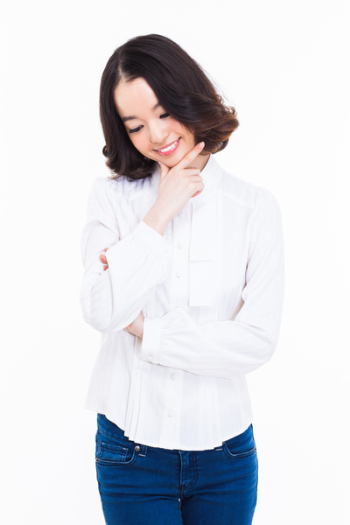 Thinking young Asian woman isolated on white background