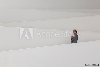 Thoughtful businessman on modern office ramp Thoughtful businessman on modern office ramp