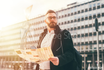 Thoughtful man using map while traveling in city