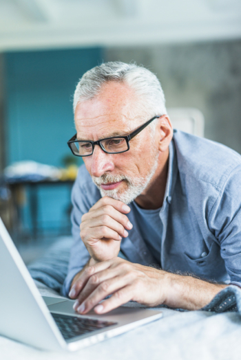 Thoughtful senior man browsing on laptop Thoughtful senior man browsing on laptop