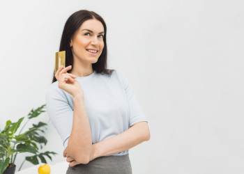 Thoughtful woman standing with credit card Thoughtful woman standing with credit card