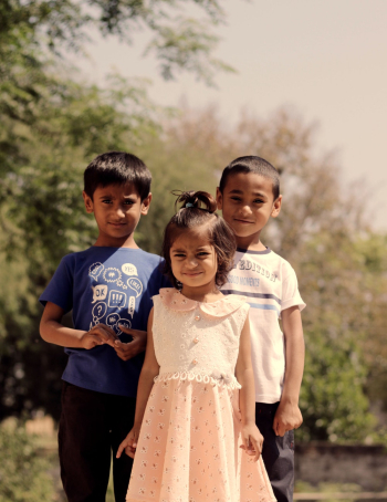 Three Children Standing Beside Tree Three Children Standing Beside Tree
