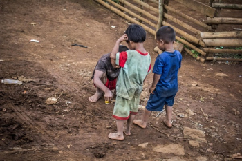 Three Children Standing on Brown Soil Three Children Standing on Brown Soil