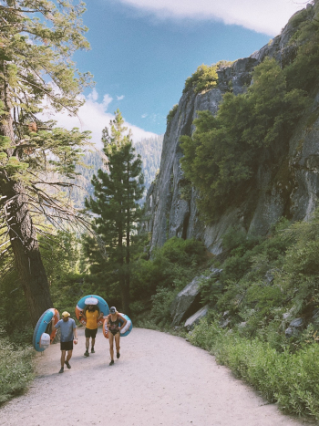 Three Person Walking in a Road Near Cliff Three Person Walking in a Road Near Cliff