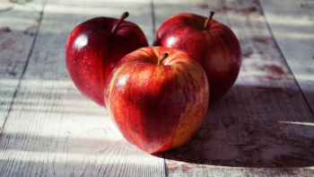 Three Red Apples on Wooden Surface Three Red Apples on Wooden Surface