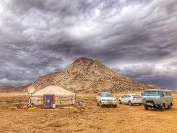 Three Vehicles Beside Mountain Under Cloudy Sky Three Vehicles Beside Mountain Under Cloudy Sky