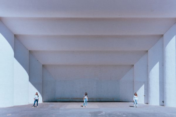 three women standing near white concrete building during daytime