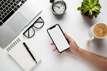 Top view desk with hand holding phone mock-up Free Photo