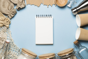 Top view empty notepad with eco friendly objects Free Photo