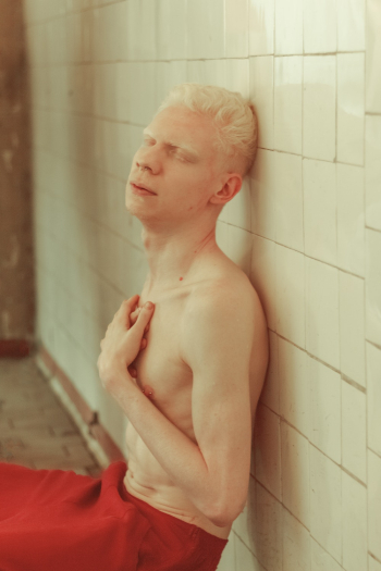 Topless Man Leaning on Tile Wall Topless Man Leaning on Tile Wall
