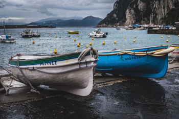 two blue and white canoe boats on seashore two blue and white canoe boats on seashore