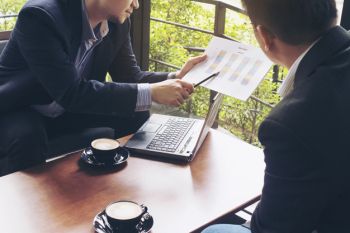 Two businessman discussing their chart in coffee shop Two businessman discussing their chart in coffee shop