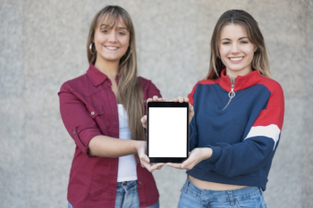 Two females holding tablet mock-up Free Photo