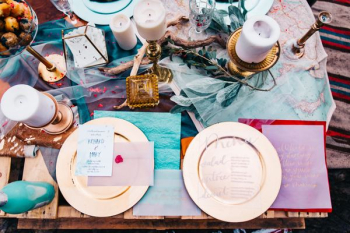 two gold-colored plates on brown wooden table two gold-colored plates on brown wooden table