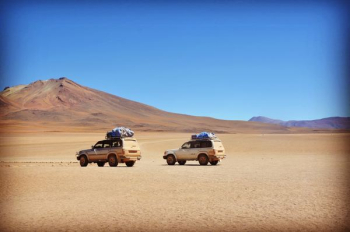 two grey SUV's on grey desert two grey SUV's on grey desert