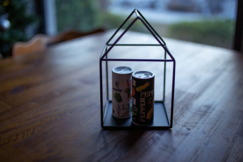 Two Labeled Thin Cans on Black Frame Two Labeled Thin Cans on Black Frame