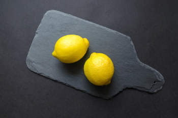 Two Lemons on Black Wooden Pad Two Lemons on Black Wooden Pad