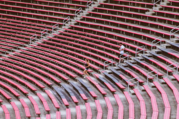 two man and woman jogging on stadium bench two man and woman jogging on stadium bench