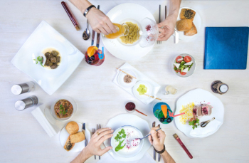 Two men having lunch with dushbara, dovga, dolma, rice and chicken wrap Free Photo
