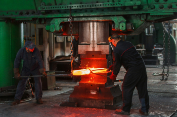Two Men Holding Two Gray Metal Tools Two Men Holding Two Gray Metal Tools
