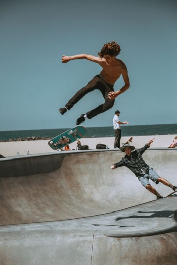 two men skateboarding on bowl ramp two men skateboarding on bowl ramp