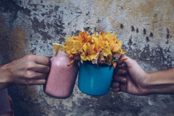 two people holding vases of flowers two people holding vases of flowers