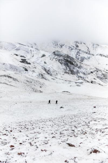 two people walking on snow two people walking on snow