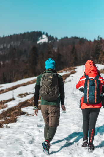 Two People Walking On Snow Trail Two People Walking On Snow Trail