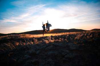 Two Person Jumping on Brown Soil Two Person Jumping on Brown Soil
