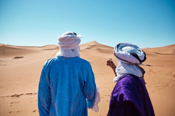 two persons standing on desert