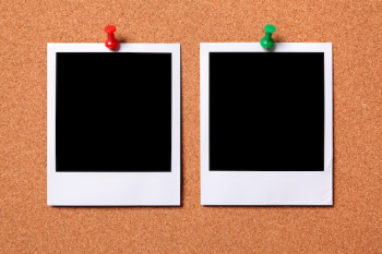 Two polaroid photo prints on a cork notice board 