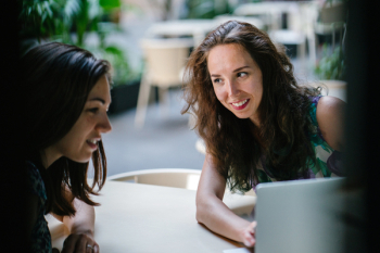 Two Talking Women While Using Laptop Two Talking Women While Using Laptop
