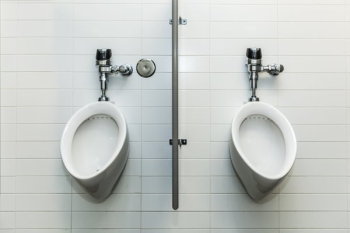 Two Urinals On White Tile Wall Two Urinals On White Tile Wall