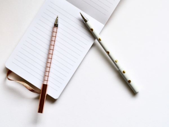 two white and beige pens on white paper two white and beige pens on white paper