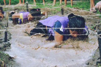 two women crawling on mud with rope two women crawling on mud with rope